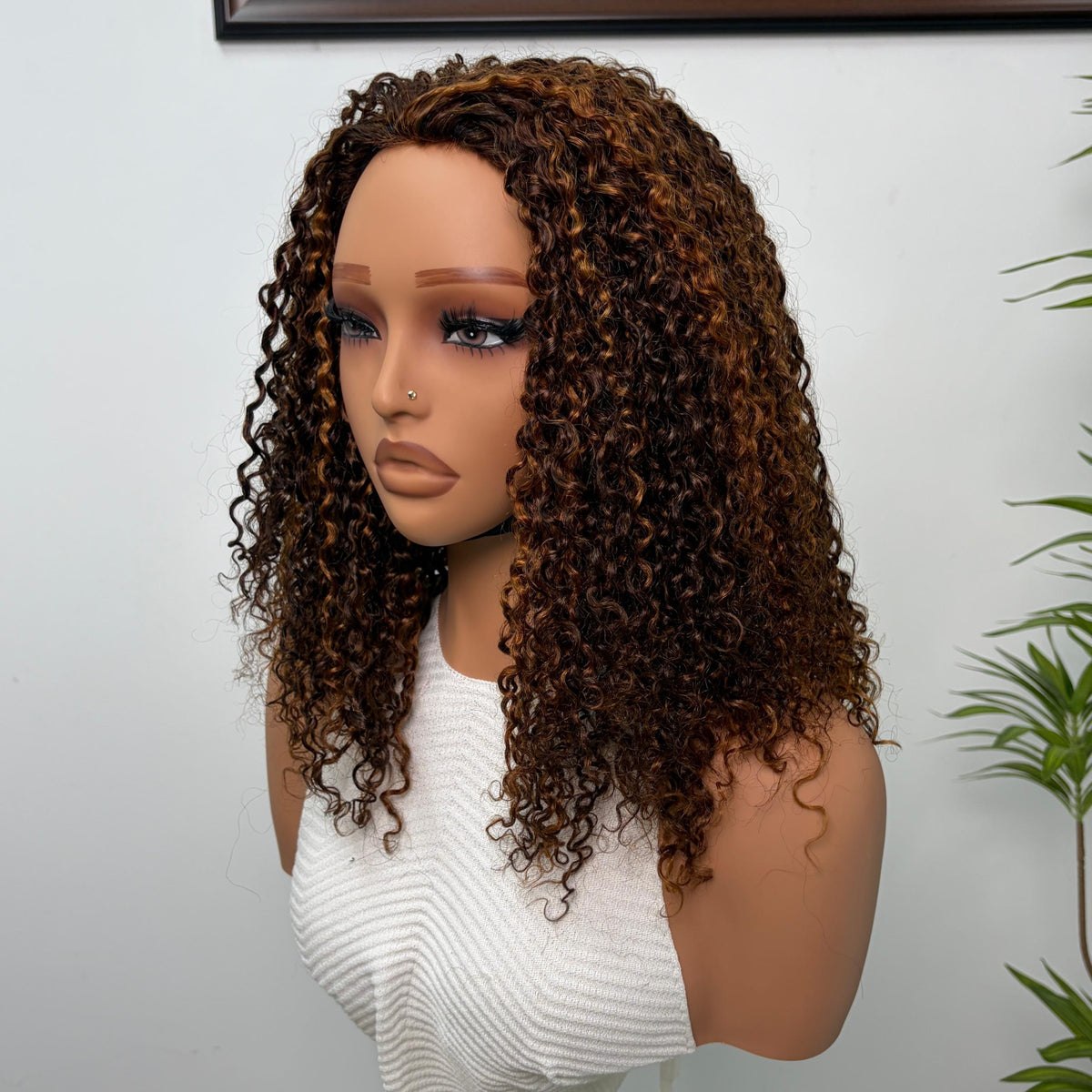 Perruque Olahair mi-longue avec boucles serrées brun profond et reflets caramel sur mannequin